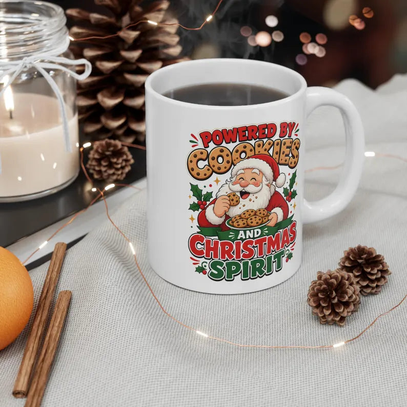 White handled mug with Santa eating cookies and Powered by Cookies and Christmas Spirit lettering.